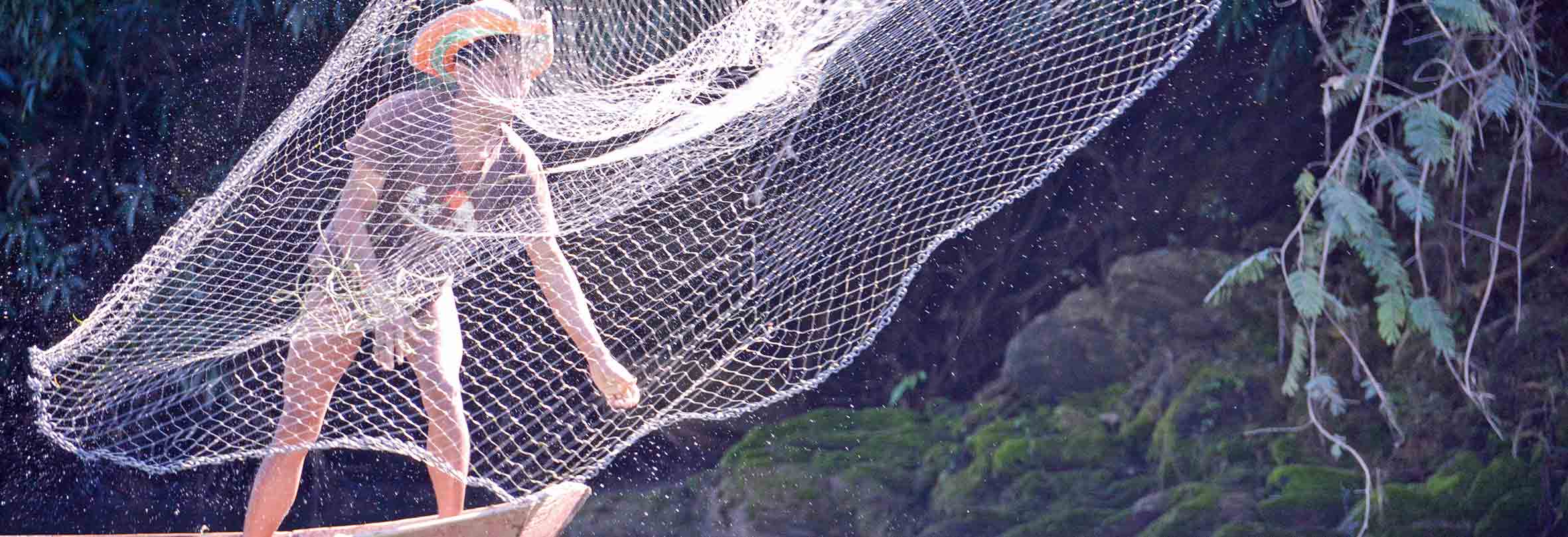 Ein Fischer wirft sein Netz aus, Laos